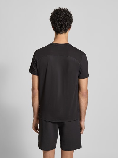 Männermodel trägt Regular Fit T-Shirt mit Rundhalsausschnitt von PUMA PERFORMANCE aus Baumwoll-Viskose-Mix, Logo-Print, schwarze Farbe, Ganzkörperansicht Rückansicht.