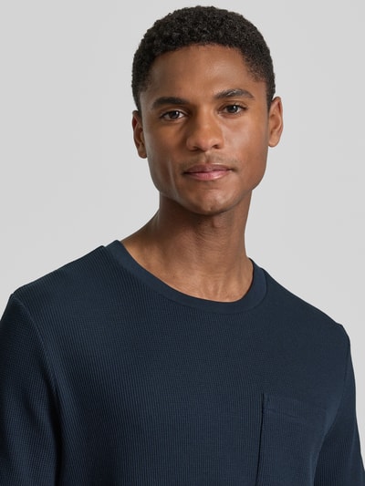 Mannenmodel draagt Regular Fit T-shirt uit katoenmix van s.Oliver RED LABEL, look: effen, piqué structuur, borstzak, ronde hals, korte mouw, Nahaufnahme Oberkörper.