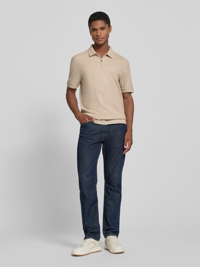 Männermodel trägt Regular Fit Poloshirt mit Strukturmuster Modell 'Tibaris' von JOOP! COLLECTION, beige, Label-Stitching, Polokragen, Reißverschluss, Rückenlänge bei Größe M 70 cm, Ganzkörperansicht von vorne.