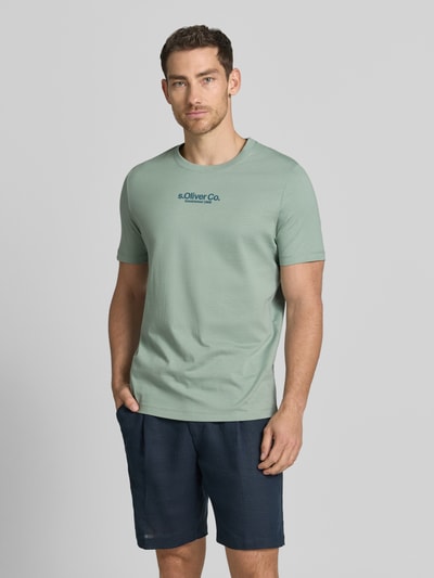 Mannenmodel draagt Regular Fit T-Shirt aus reiner Baumwolle van s.Oliver RED LABEL, effen lichtgroen, korte mouwen, ronde hals, labelprint, puur katoen. Ganzlichaamsaanzicht van voren.