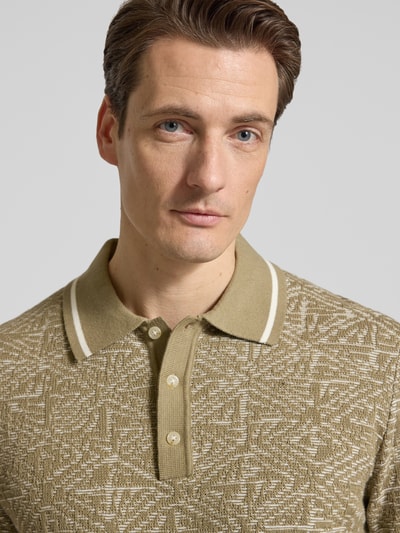 Männermodel trägt Regular Fit Poloshirt im Allover-Look von Jack & Jones Premium aus reiner Baumwolle, Knopfleiste, Nahaufnahme Oberkörper.