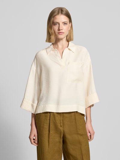Vrouwenmodel draagt blouse met borstzak en V-hals model 'Felmara' van OPUS, modalmix, loose fit, platte kraag, oversneden schouders, mouwen met omslag, verlengde rug, ruglengte maat 36: 57 cm, mouwlengte maat 36: 35 cm, crèmekleurig, losse vorm, zachte textuur, geheel lichaamsaanzicht van voren.