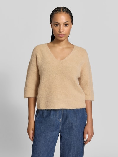 Vrouwenmodel draagt Wollpullover uit Alpaka-Woll-Mix van Juvia, los model, v-hals, tricotlook, 3/4-mouw, rolzoom. Vooraanzicht, bovenlichaam.