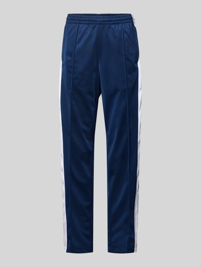 Produktfoto, Straight Fit Jogginghose mit elastischem Bund Modell 'Adibreak' von adidas Originals in Dunkelblau mit weißen Seiteneinsätzen, Ziernähte, Eingrifftaschen, Damenmodell, klar erkennbare Struktur, neutraler Hintergrund
