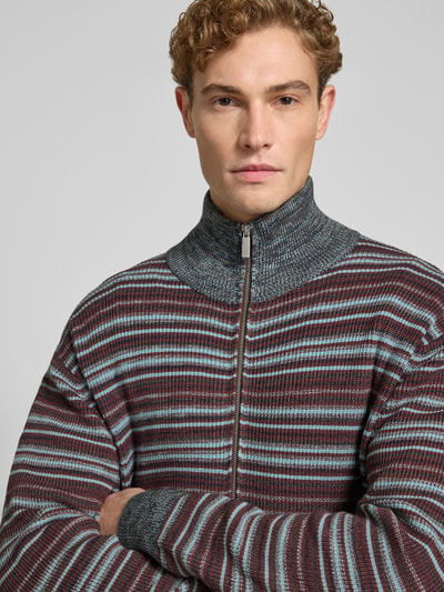 Männermodel trägt Regular Fit Strickjacke aus Viskose-Mix von Jake*s Studio Men, gestreift in Braun, Blau und Grau, Nahaufnahme Oberkörper.