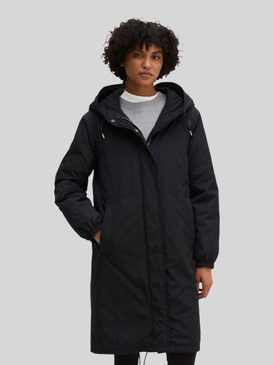 Modelka nosi czarną parkę Regular Fit Parka mit Kapuzenkragen von Marc O'Polo o matowej fakturze, widok całej sylwetki z przodu.