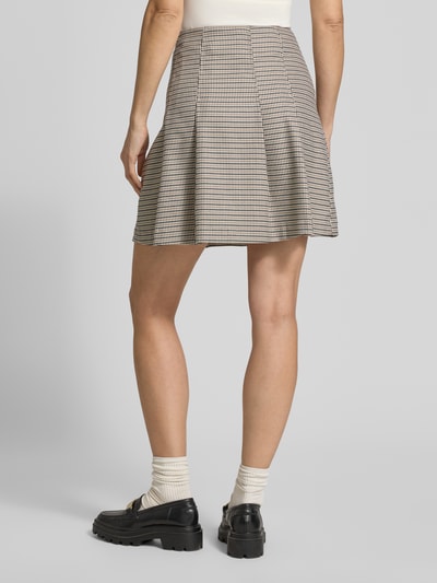 Frauenmodel trägt Mini-Rock mit Viskose-Anteil Modell 'ROBALLO-1' von HUGO, bi-color Pepita-Muster, A-Linie, Ganzkörperansicht Rückansicht