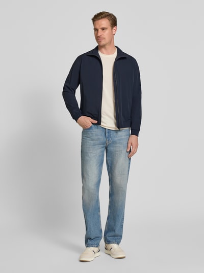 Männermodel trägt Slim Fit Jacke mit Stehkragen Modell 'Apex' von SCANDINAVIAN EDITION, dunkelblau, Elastischer-Material-Mix, Ganzkörperansicht von vorne. Rückenlänge 65 cm, Schulterbreite 45 cm, Brustweite 42 cm, Ärmellänge 65 cm, Zweiwege-Reißverschluss, elastische Abschlüsse.