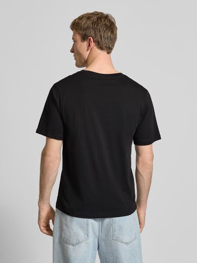 Männermodel trägt Regular Fit T-Shirt mit Logo-Print von JACK & JONES in Schwarz aus reiner Baumwolle, Ganzkörperansicht Rückansicht.