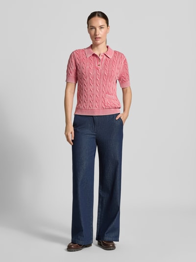 Frauenmodel trägt Slim Fit Poloshirt aus reiner Baumwolle von Jake*s Casual in Rosa mit Zopfmuster zu blauer Hose, Ganzkörperansicht von vorne.
