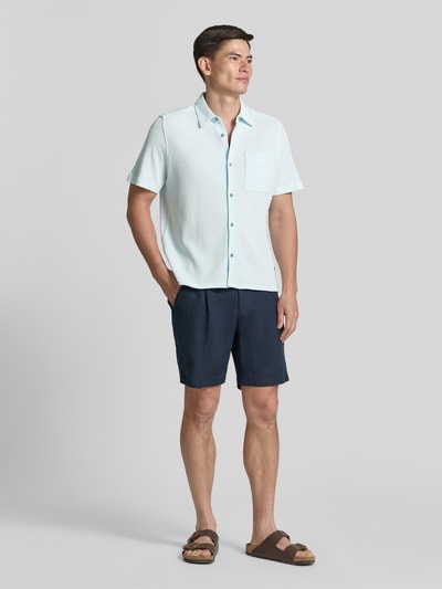 Männermodel trägt Regular Fit Freizeithemd aus Baumwoll-Mix von s.Oliver RED LABEL in Hellblau mit Waffelstruktur und Kentkragen, Ganzkörperansicht von vorne