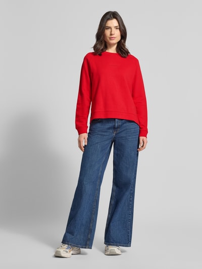 Modelka kobieca ma na sobie Regular Fit Sweatshirt aus reiner Baumwolle od Marc O'Polo Denim, efekt: jednolity kolor, krój regular fit, nadruk z logo, dekolt okrągły, rękawy długie, zakończenia prążkowane, rozcięcia z boku, bawełna, zdjęcie: pełna sylwetka z przodu.