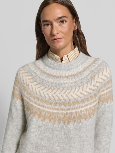 Frauenmodel trägt Pullover aus Alpaka Wolle mit Jacquardstruktur von Barbour, mehrfarbig, geometrisches Muster, Nahaufnahme Oberkörper.