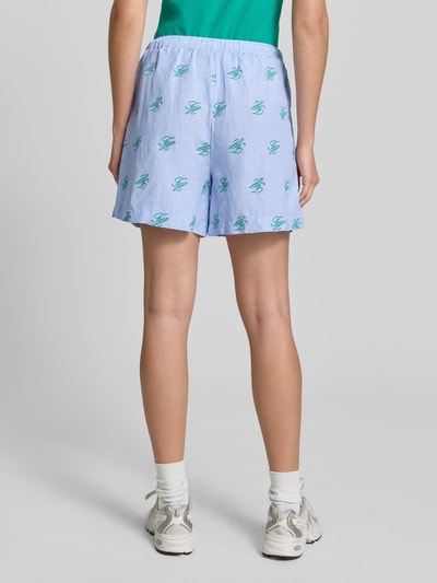 Vrouwenmodel draagt Relaxed Fit Shorts met Logo-Stitching uit linnenmix van Tommy Hilfiger, blauw-wit gestreept allover patroon, zijzakken, elastische taille met tunnelkoord, detailopname achterkant.