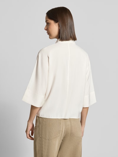 Frauenmodel trägt Loose Fit Kurzarmbluse aus Modal-Mix Modell 'Fotori' von OPUS in Creme, Beigehose, glatte Struktur, Ganzkörperansicht Rückansicht. Damen Kurzarmbluse von OPUS.