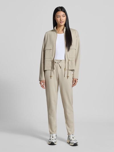 Vrouwenmodel draagt Regular fit sweatjack uit katoenmix van JOOP! in beige, met zakken vooraan, gladde textuur, volledige lichaamsvooraanzicht.