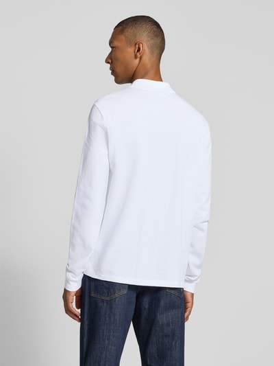 Männermodel trägt Regular Fit Poloshirt aus reiner Baumwolle von Lacoste in Weiß, strukturierte Oberfläche, Ganzkörperansicht Rückansicht.