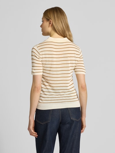 Frauenmodel trägt Strickshirt mit Polokragen und kurzer Knopfleiste Modell 'TENCYP' von Mango in Creme mit braunen Streifen, Modern Fit, gerippte Abschlüsse, Rückenlänge 53 cm, Ärmellänge 21 cm, Ganzkörperansicht Rückansicht.