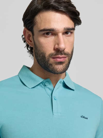 Männermodel trägt Regular Fit Poloshirt aus reiner Baumwolle von s.Oliver RED LABEL in Unifarbe mit Polokragen und Label Stitching, Nahaufnahme Oberkörper.