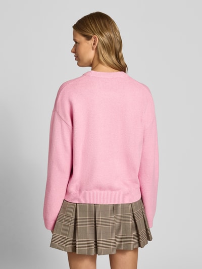 Vrouwenmodel draagt Strickpullover mit Rundhalsausschnitt van JJXX in roze, katoenmix met stretch, relaxed fit, ruglengte 56 cm, mouwlengte 55 cm, overgesneden schouders, Ganzlichaamsaanzicht achterkant.