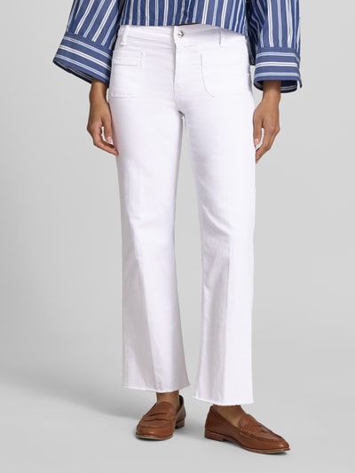 Frauenmodel trägt Relaxed Fit Jeans aus Baumwoll-Mix Modell 'TESS' von Cambio in weißer Denim-Optik mit Fransen, Ankle-Länge, Logo-Applikation, Label-Patch, Gürtelschlaufen, Knopf und verdecktem Reißverschluss, Gesäßtaschen, aufgesetzte Taschen, Materialverarbeitung Twill, Ganzkörperansicht von vorne.