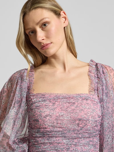 Frauenmodel trägt Cocktailkleid mit Karree-Ausschnitt von LACE & BEADS, rosa Mesh, Rüschen, tailliert, Nahaufnahme Oberkörper.