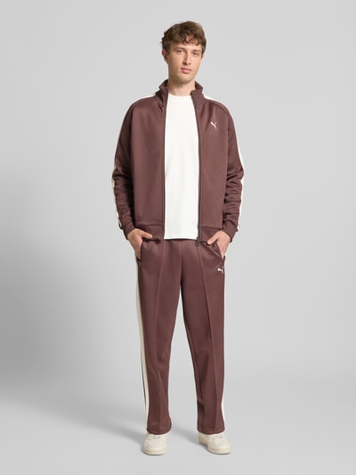 Männermodel trägt Straight Fit Sweatpants mit Logo-Stitching Modell 'Always On' von PUMA PERFORMANCE in Braun mit Ziernähte und Eingrifftaschen, Material-Mix mit Baumwoll-Anteil, Ganzkörperansicht von vorne.