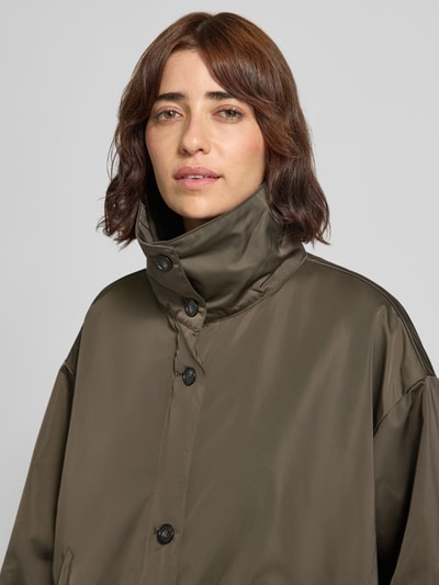 Frauenmodel trägt Regular Fit Blouson mit geknöpften Seitenschlitzen von Marc O'Polo in Olivgrün mit matter glatter Textur, Nahaufnahme Oberkörper, Damen Blouson von Marc O'Polo.