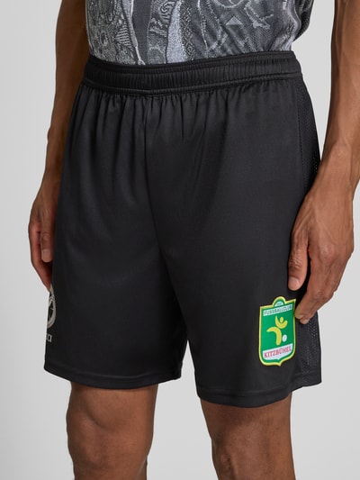 Männermodel trägt Relaxed Fit Shorts mit Logo-Print von COLUCCI, schwarze Farbe, Motiv-Stitching, elastischer Bund, Nahaufnahme Oberkörper. Bundweite 38 cm, Innenbeinlänge 18 cm, Herren Shorts.