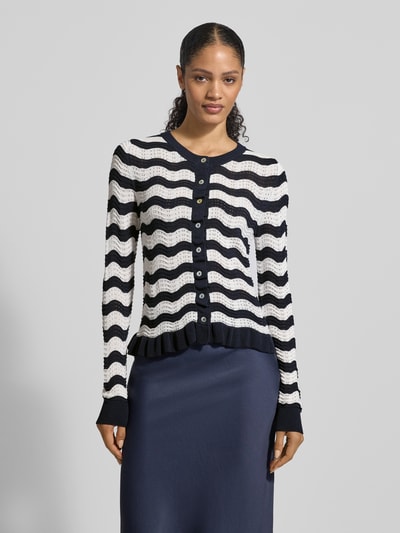 Vrouwenmodel draagt Strickjacke mit Rundhalsausschnitt und Knopfleiste van Christian Berg Woman Selection, materiaalmix met viscose, regular fit, ronde hals, knoopsluiting, ruglengte maat 36: 53 cm, mouwlengte maat 36: 70 cm, zwart-witte zigzagstrepen, gestructureerde stof, voorkant, halfbody shot.