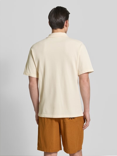 Mężczyzna nosi Relaxed Fit Poloshirt in Pique-Optik od Scotch & Soda, bawełna, piqué, jasny beż, krótkie rękawy, widok całej sylwetki z tyłu.