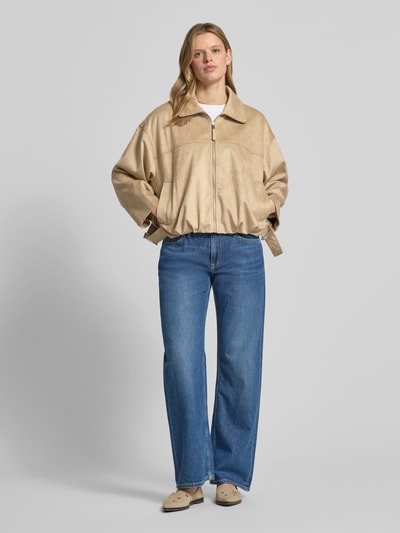 Frauenmodel trägt Jacke in Leder-Optik mit Reißverschluss und Eingrifftaschen von Gina Tricot, Relaxed-Fit, Material-Mix, Ganzkörperansicht von vorne.