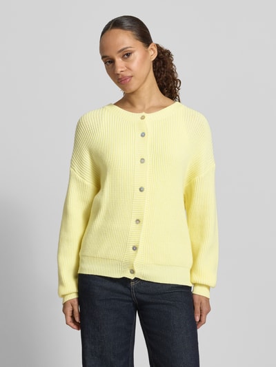 Frauenmodel trägt Regular Fit Strickjacke aus Viskose-Mix Modell 'LENI' von VILLA SOPHIE in Gelb, unifarben, Strukturstrick, Ganzkörperansicht von vorne.