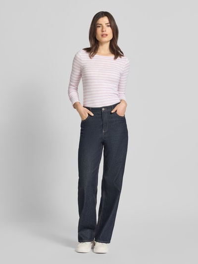 Frauenmodel trägt Regular Fit Langarmshirt aus reiner Baumwolle von Marc O'Polo mit Allover-Streifenmuster und U-Boot-Ausschnitt in Weiß und Rosa, Ganzkörperansicht von vorne.
