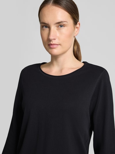 Vrouwenmodel draagt Regular Fit 3/4-shirt uit puur katoen van s.Oliver RED LABEL, effen zwart, zachte textuur, close-up bovenlichaam.