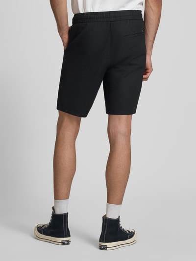 Männermodel trägt Regular Fit Bermudas aus Baumwoll-Leinen-Mix Modell 'LINUS' von Only & Sons, unifarben, elastischer Bund, Rückansicht Ganzkörperansicht.