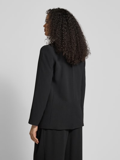 Frauenmodel trägt schwarzen Relaxed Fit Blazer mit Reverskragen von ARMANI EXCHANGE, Pattentaschen und Knopfverschluss, Ganzkörperansicht Rückansicht.