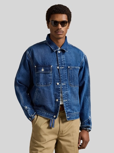 Mannenmodel draagt Regular Fit Jeansjacke aus reiner Baumwolle van Polo Ralph Lauren in effen blauw denim met borstzakken, voorkant bovenlichaam close-up.