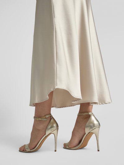 Frauenmodel trägt Midirock mit Stretch-Anteil Modell 'Fabiola' von GUIDO MARIA KRETSCHMER WOMAN in Satin, A-Linie, Midilänge, Nahaufnahme Unterkörper.