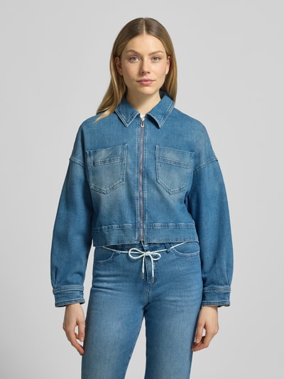 Vrouwenmodel draagt Cropped Jeansjacke aus Baumwoll-Mix van Marc Cain in blauw katoenmix, recht pasvorm, platte kraag, ritssluiting, borstzakken; ruglengte maat 36: 48 cm, schouderbreedte: 44 cm, borstwijdte: 50 cm, mouwlengte: 52 cm. Ganzkörperansicht van voren.
