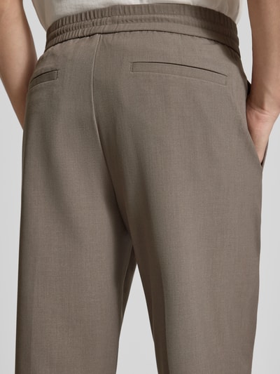 Männermodel trägt Relaxed Fit Hose mit elastischem Bund von Lindbergh in Taupe, Material-Mix mit Viskose-Anteil, Detailaufnahme Rückansicht.