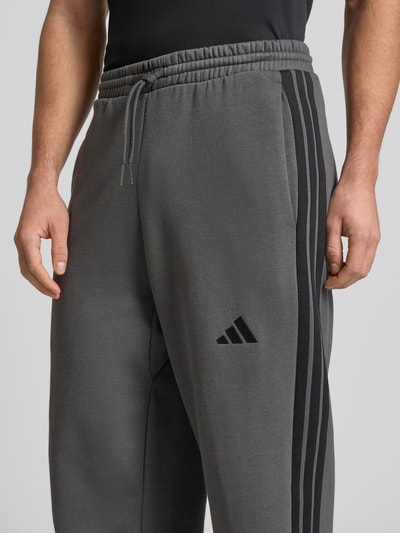 Männermodel trägt Sweatpants mit elastischem Bund und Tunnelzug von adidas Sportswear, Baumwoll-Mix, Regular Fit, Nahaufnahme Oberkörper.