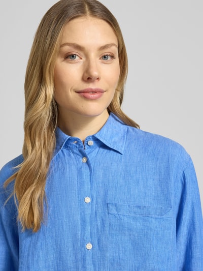 Frauenmodel trägt Relaxed Fit Longbluse aus Leinen Modell 'TAHIA' von 0039 Italy in Blau mit Hemdblusenkragen, Knopfleiste, Brusttasche, Nahaufnahme Oberkörper, reines Leinen, Rückenlänge 86 cm, Ärmellänge 58 cm bei Größe S.