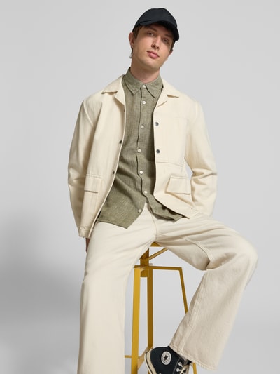 Männermodel trägt Slim Fit Freizeithemd aus Leinen-Baumwoll-Mix Modell 'NELSON' von Redefined Rebel in Oliv mit Kentkragen, Ganzkörperansicht von vorne.