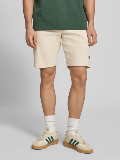 Männermodel trägt Straight Fit Shorts mit Logo-Stitching Modell 'Fillip' von Blend aus Reine Baumwolle mit Strukturmuster, Eingrifftaschen, Gesäßtaschen und elastischem Bund mit Tunnelzug, Ganzkörperansicht von vorne.