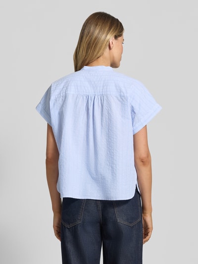 Modelka nosi Regular Fit Bluse mit Stehkragen von Milano Italy, bluzka z bawełny, krój regular fit, stójka, listwa guzikowa, krótkie rękawy, długość tyłu w rozmiarze 36: 58 cm, długość rękawów w rozmiarze 36: 28 cm, jasnoniebieska, pasek w pionowe paski, tekstura miękka, widok całej sylwetki z tyłu.