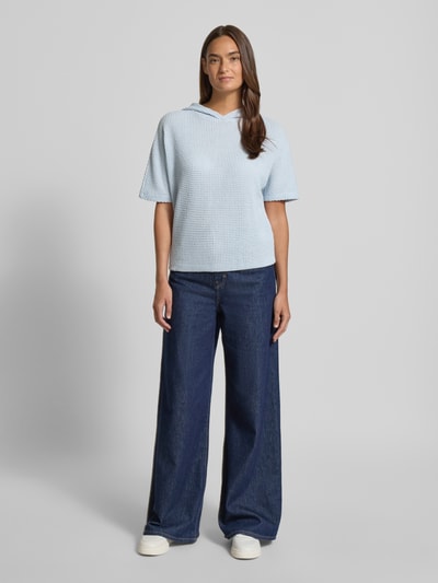 Frauenmodel trägt Strickshirt mit Kapuze Modell 'Gikaria' von OPUS, hellblau, Strukturmuster, Relaxed Fit, Ganzkörperansicht von vorne.