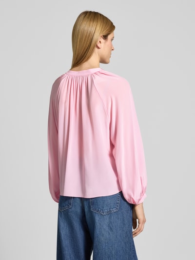 Vrouwenmodel draagt Regular Fit Bluse mit V-Ausschnitt van HERZENS in lichtroze, soepele stof, tuniekkraag, ruglengte 58 cm, detailopname rugansicht.