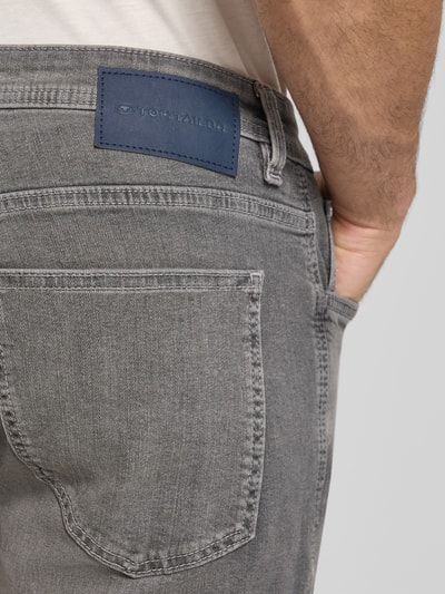 Männermodel trägt Regular Fit Jeans Bermudas aus Baumwoll-Mix von Tom Tailor in grauer Denim-Optik mit Label-Patch, Detailaufnahme.