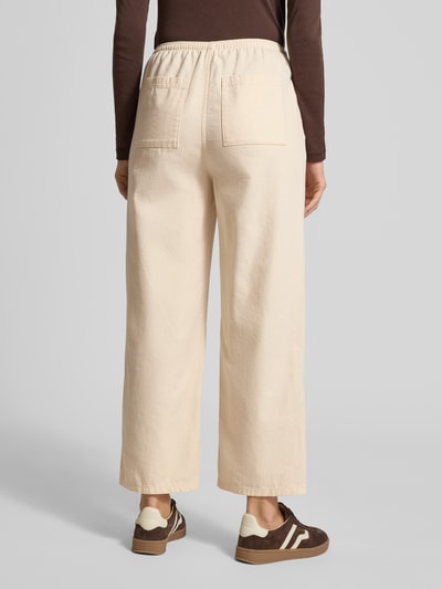 Frauenmodel trägt Wide Fit Stoffhose mit elastischem Bund Modell 'Lycaz' von American Vintage in Beige, reine Baumwolle, Ganzkörperansicht Rückansicht.